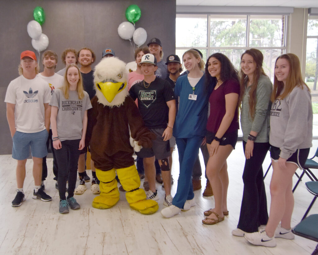 Baseball and volleyball team members welcome new cross country athlete to RCC.