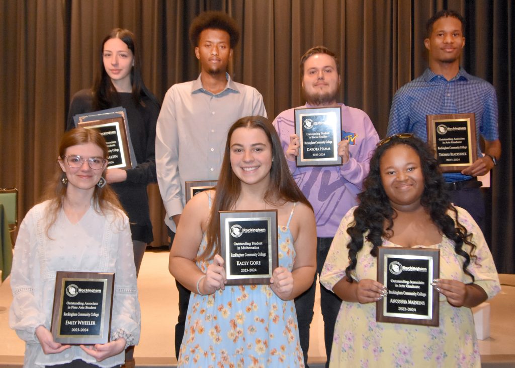 Photo of seven students holding plaques.