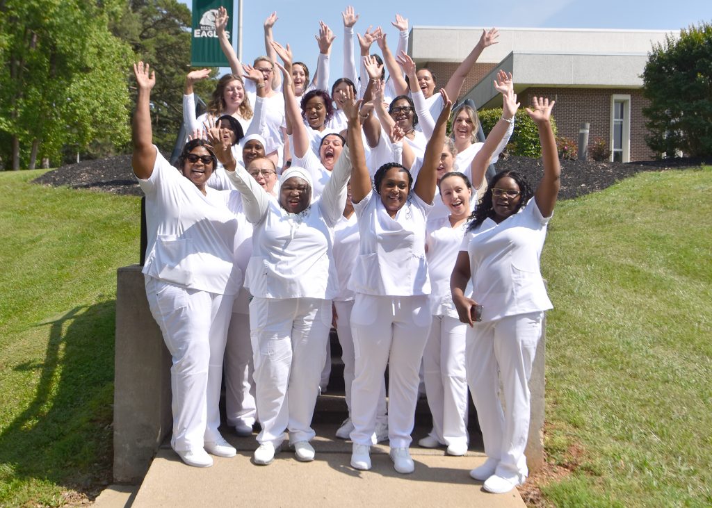 Licensed Practical Nursing to Associate Degree Nursing graduates cheer for a photo